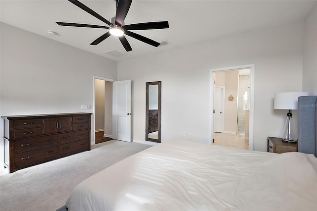 bedroom with visible vents, light colored carpet, ceiling fan, and ensuite bathroom