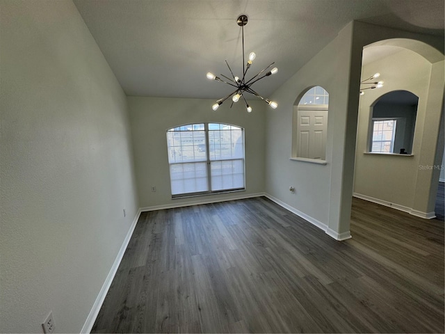 unfurnished dining area with baseboards, dark wood finished floors, arched walkways, vaulted ceiling, and a chandelier