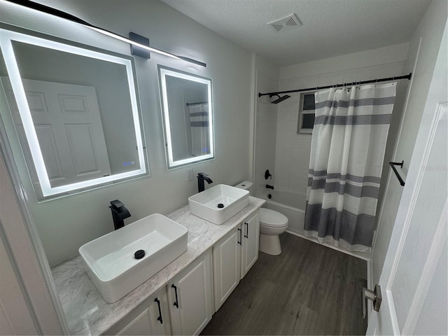 full bath featuring visible vents, toilet, wood finished floors, and a sink