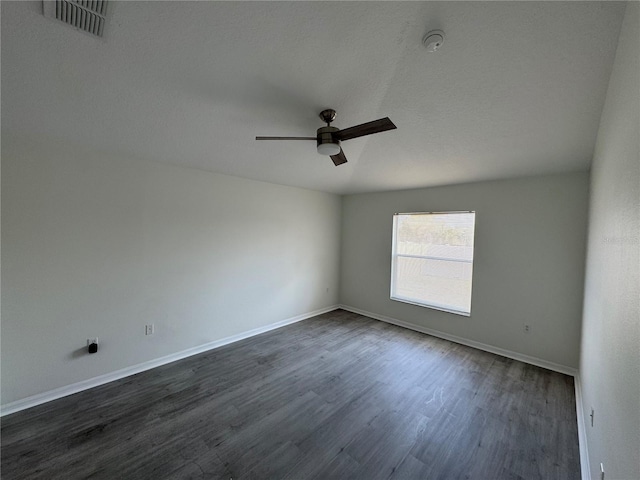 unfurnished room featuring dark wood finished floors, visible vents, baseboards, and ceiling fan