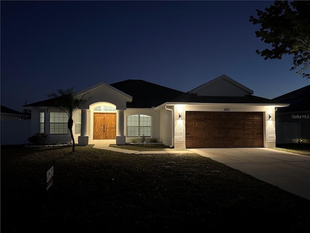 ranch-style house with concrete driveway, an attached garage, french doors, and stucco siding