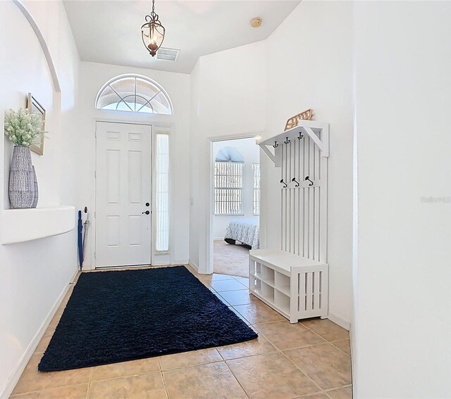 foyer with light tile patterned floors, visible vents, a healthy amount of sunlight, and baseboards