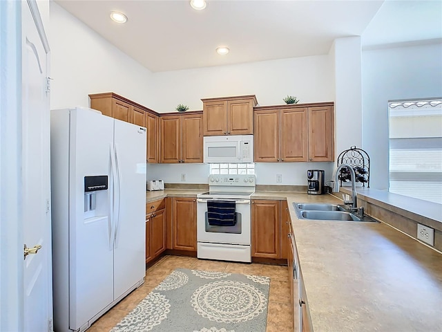 kitchen featuring light countertops, recessed lighting, brown cabinets, white appliances, and a sink