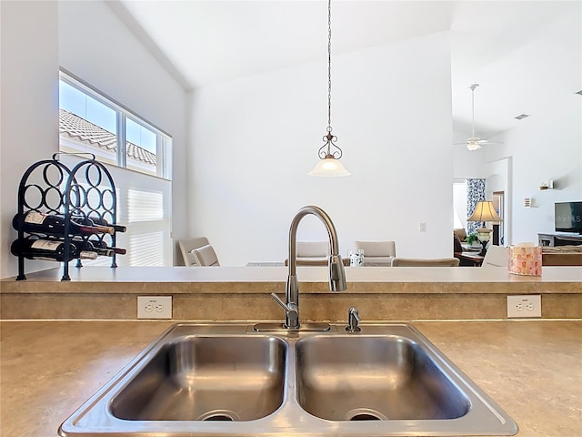 kitchen featuring hanging light fixtures, lofted ceiling, a ceiling fan, and a sink