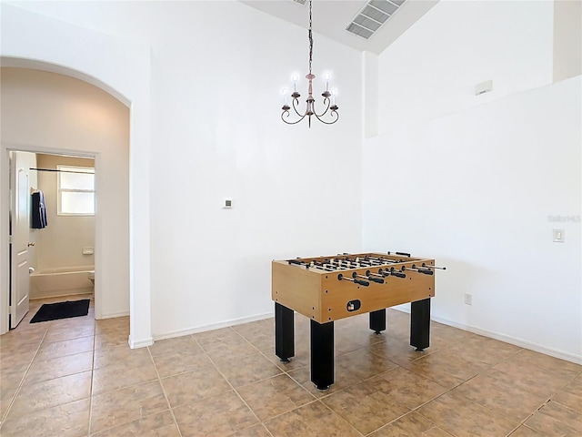 recreation room featuring visible vents, baseboards, an inviting chandelier, light tile patterned flooring, and arched walkways