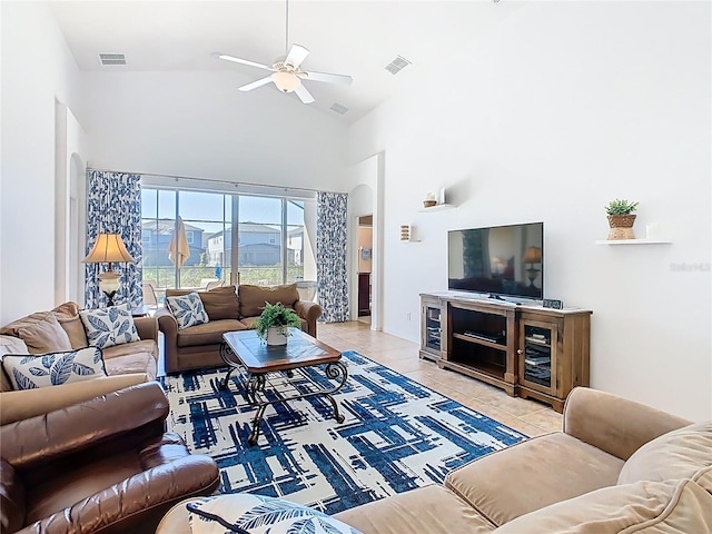 living room featuring visible vents, ceiling fan, light tile patterned floors, arched walkways, and high vaulted ceiling