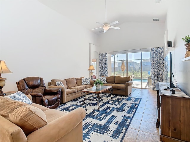 living room with light tile patterned floors, a ceiling fan, visible vents, and high vaulted ceiling