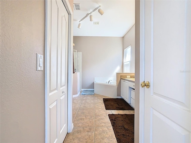 bathroom with visible vents, track lighting, tile patterned floors, a bath, and vanity