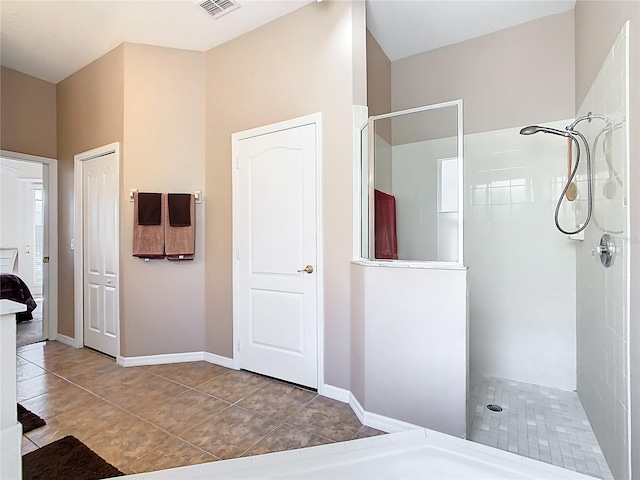 bathroom featuring tile patterned floors, visible vents, baseboards, and walk in shower