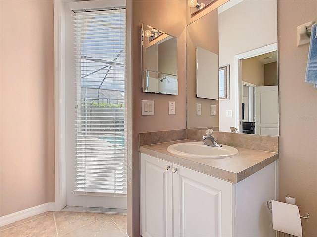 bathroom with tile patterned flooring, vanity, a healthy amount of sunlight, and baseboards