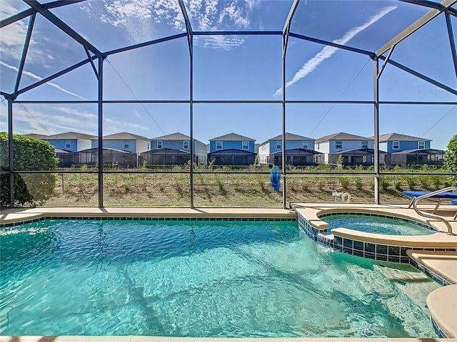 view of pool featuring a lanai, a residential view, a pool with connected hot tub, and a patio