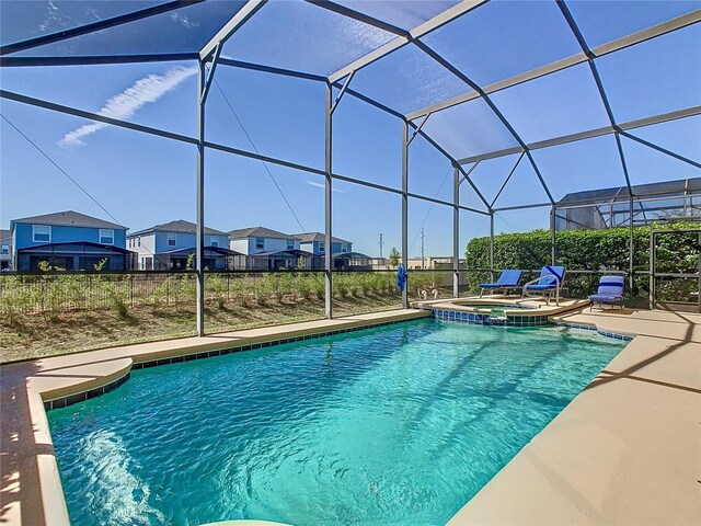 view of swimming pool with a patio area, a residential view, glass enclosure, and a pool with connected hot tub