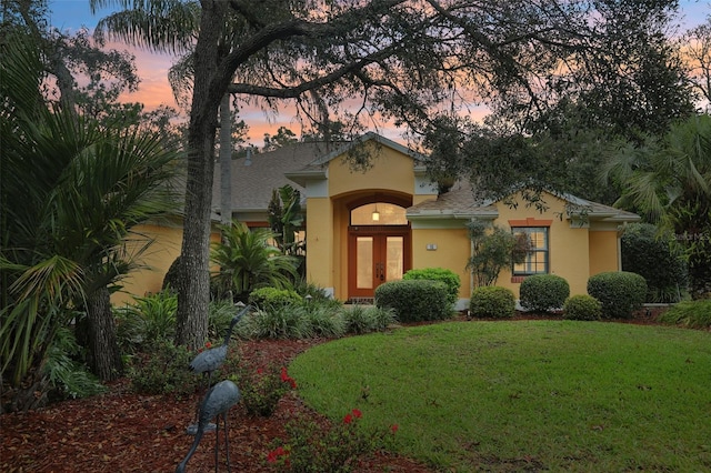 mediterranean / spanish house featuring stucco siding and a lawn