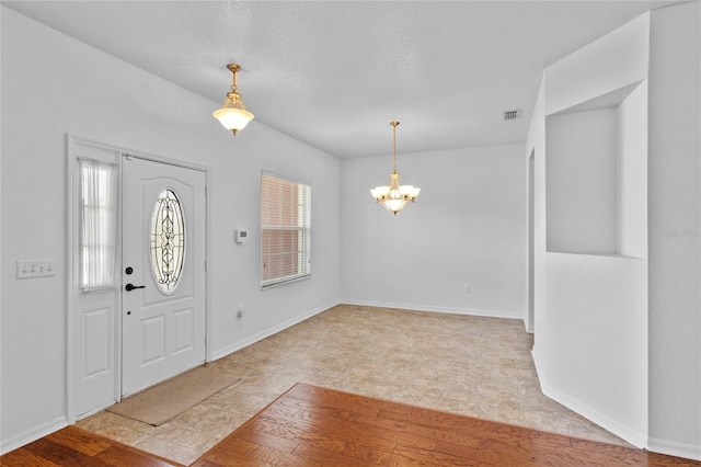 entryway featuring a wealth of natural light, visible vents, a notable chandelier, and wood finished floors