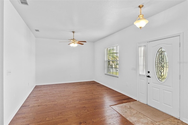 entryway with baseboards, wood finished floors, visible vents, and ceiling fan