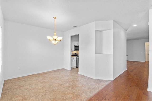 spare room featuring visible vents, baseboards, recessed lighting, light wood-style floors, and an inviting chandelier