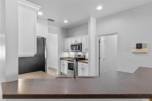 kitchen with visible vents, recessed lighting, white cabinets, appliances with stainless steel finishes, and dark countertops