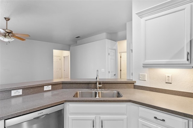 kitchen featuring dark countertops, a sink, white cabinets, a ceiling fan, and stainless steel dishwasher