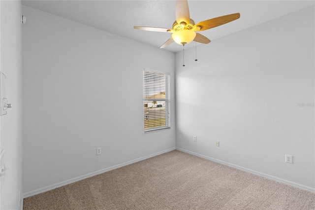 carpeted spare room with baseboards and a ceiling fan