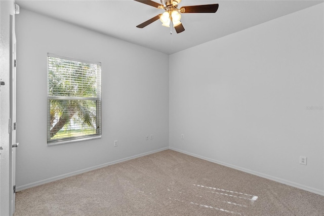 empty room featuring baseboards, carpet floors, and ceiling fan