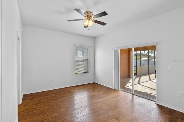 interior space with baseboards, wood finished floors, a ceiling fan, and access to outside