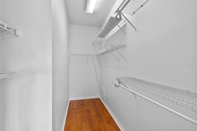 walk in closet featuring wood finished floors and visible vents