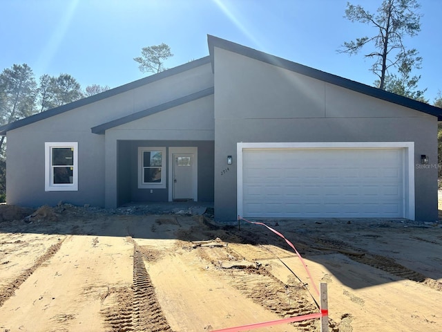 view of front facade with a garage and stucco siding