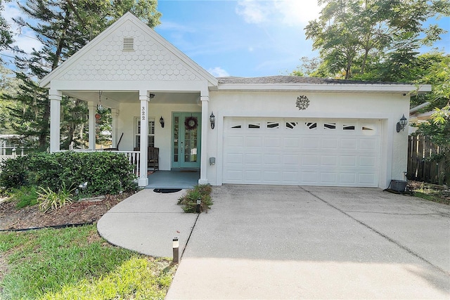 view of front of home with an attached garage, covered porch, driveway, and stucco siding