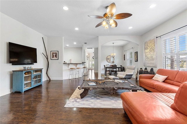 living room with recessed lighting, baseboards, arched walkways, and wood finished floors