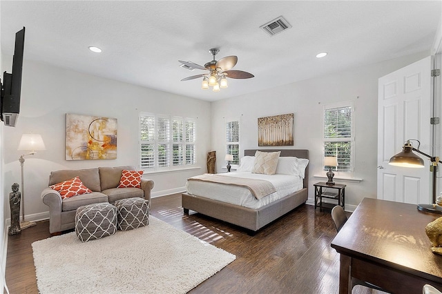 bedroom featuring dark wood finished floors, visible vents, multiple windows, and baseboards