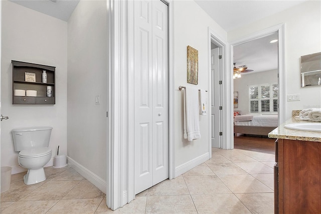 bathroom with tile patterned flooring, toilet, ensuite bathroom, a closet, and vanity