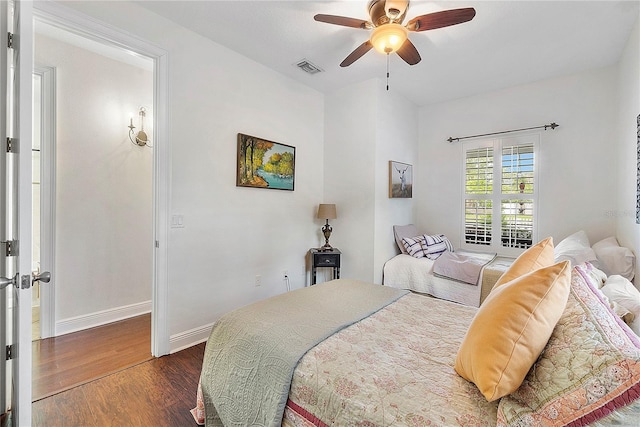 bedroom featuring visible vents, baseboards, dark wood-type flooring, and a ceiling fan