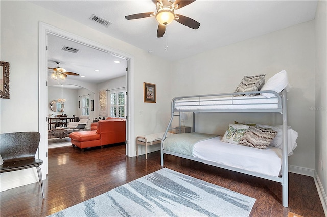 bedroom featuring visible vents, baseboards, wood finished floors, and a ceiling fan