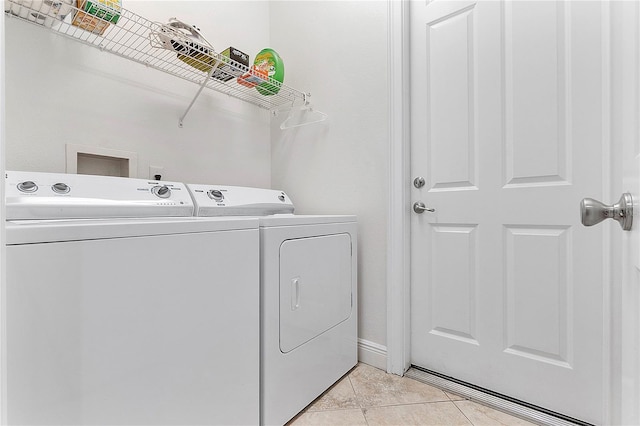 laundry area featuring light tile patterned floors, laundry area, baseboards, and separate washer and dryer