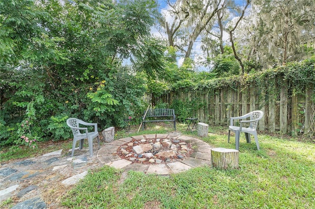 view of yard with fence and an outdoor fire pit