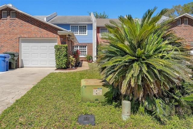 view of front of property with a garage, a front yard, brick siding, and driveway