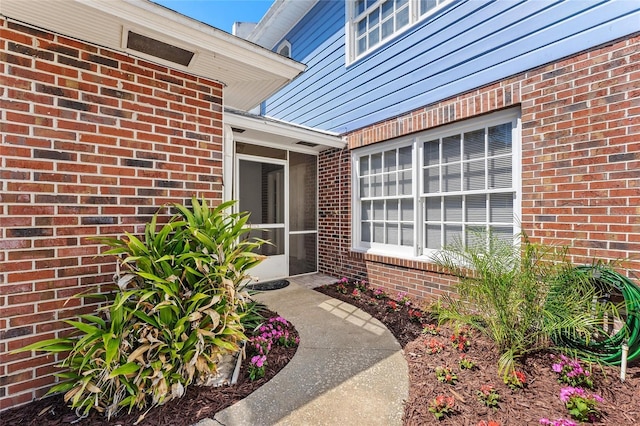 view of exterior entry with brick siding