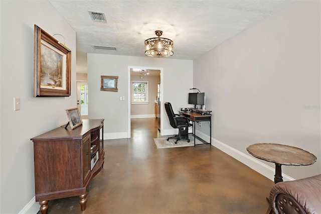 office area with visible vents, a textured ceiling, concrete flooring, and baseboards