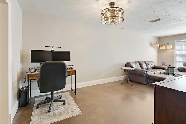 office space featuring finished concrete floors, visible vents, a textured ceiling, and baseboards