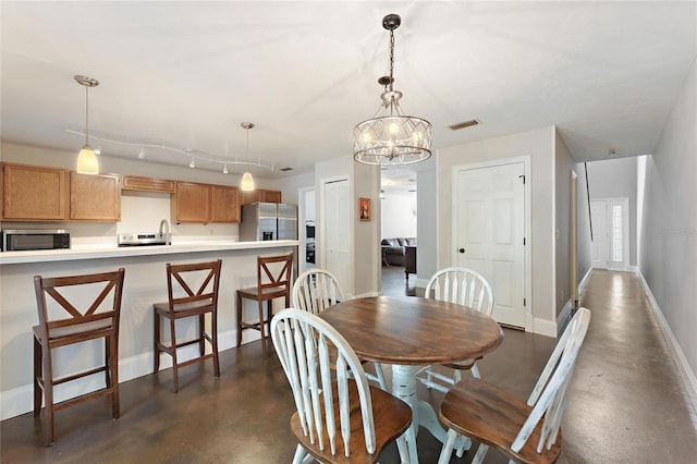 dining space featuring visible vents, baseboards, concrete flooring, and a chandelier