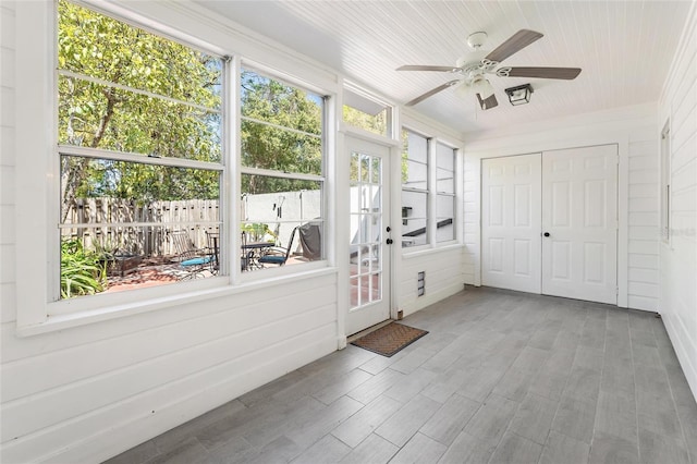 unfurnished sunroom with wood ceiling and ceiling fan