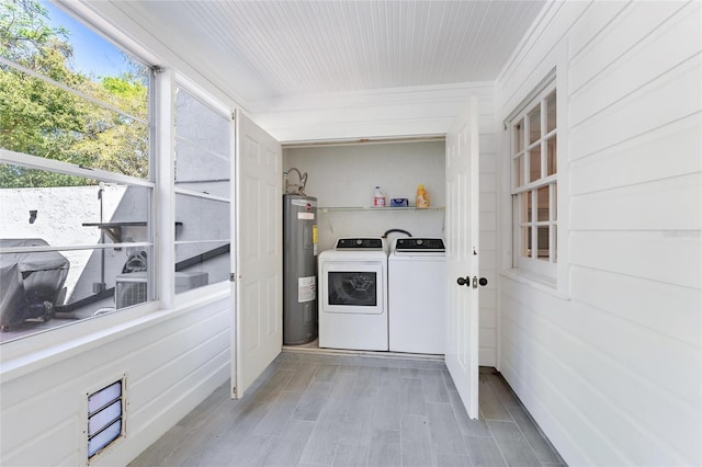 laundry area with separate washer and dryer, wood finished floors, water heater, and laundry area