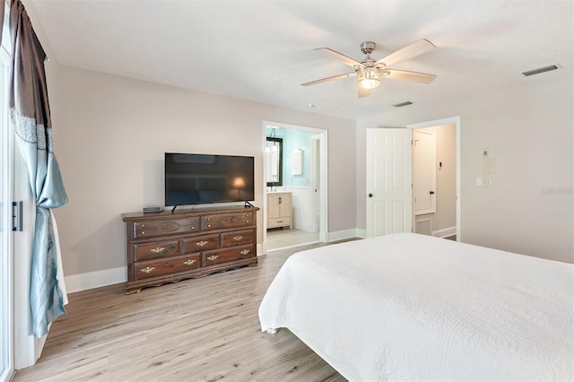 bedroom with ensuite bath, visible vents, baseboards, and light wood finished floors