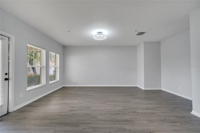 empty room featuring visible vents, baseboards, and wood finished floors