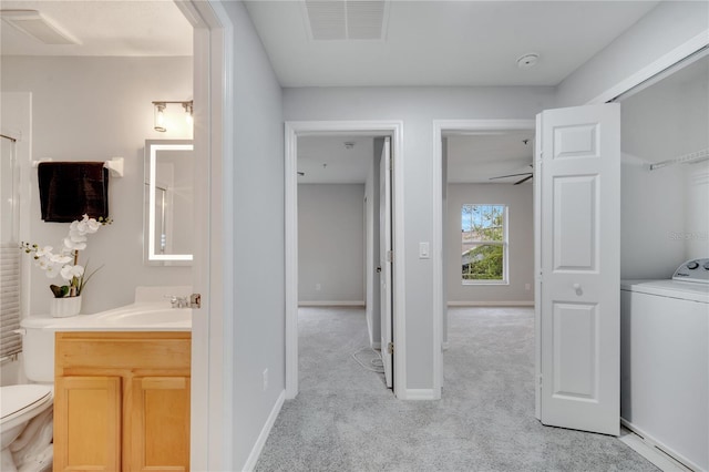 bathroom featuring vanity, washer / clothes dryer, baseboards, and visible vents