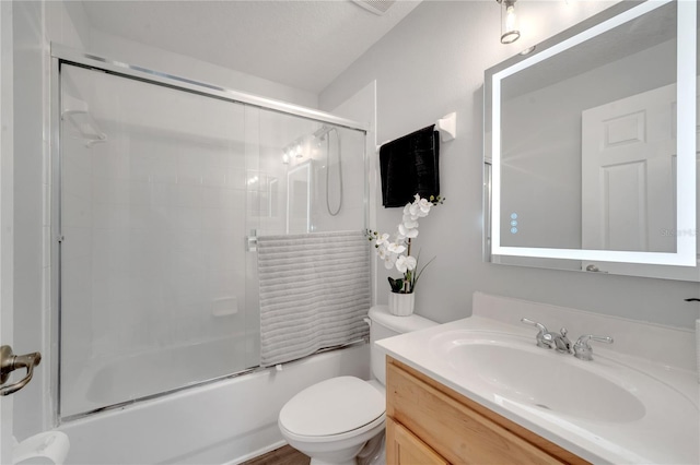 full bath featuring toilet, vanity, and shower / bath combination with glass door