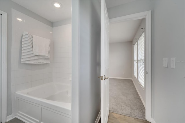 full bathroom featuring baseboards and a tub to relax in