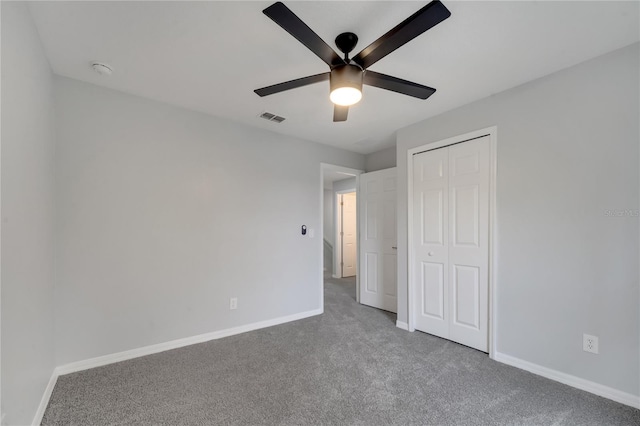 unfurnished bedroom with carpet, visible vents, baseboards, ceiling fan, and a closet