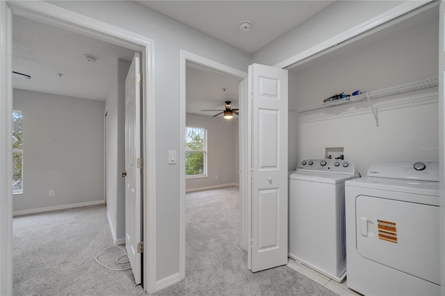 laundry area with washing machine and clothes dryer, laundry area, light colored carpet, and baseboards