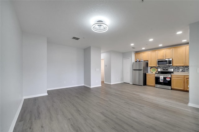 2026 Cypress Bay Blvd, Kissimmee, FL 34743 - kitchen with stainless steel appliances, recessed lighting, light wood-style flooring, decorative backsplash, and light countertops
